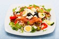 Salad with salmon, fresh tomato, cucumber and quail eggs at plate