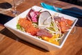 Salad of seafood on table. Sliced raw salmon, tuna, soy sprout with avocado sauce Royalty Free Stock Photo