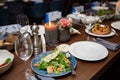 Salad shown close-up, in the background a dining room of a restaurant