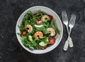 Salad with shrimp, arugula,avocado, cherry tomatoes on a dark background, top view Royalty Free Stock Photo