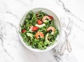 Salad with shrimp, arugula,avocado, cherry tomatoes on a light marble background, top view Royalty Free Stock Photo