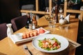 Salad of shrimp, avocado, tomato, lettuce and lemon. A white plate, a table in the restaurant. Sushi Sesame Maki