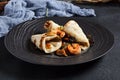 Salad with shrimp and pita bread. Seafood and vegetable on black ceramic plate.  Gourmet, restaurant healthy food concept. Dark Royalty Free Stock Photo