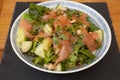A salad with smoked salmon and mixed greens with a salad dressing and mixed herbs Royalty Free Stock Photo