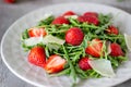 Salad of strawberries, arugula and cheese on a grey background. Dietary food. Royalty Free Stock Photo