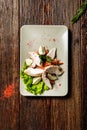 Salad with stuffed chicken fillet and eggs on white plate on wooden background Royalty Free Stock Photo