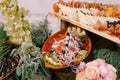 Salad with tomato and black olives in a plate and plank of cheese and prosciutto on a table with flowers. Royalty Free Stock Photo