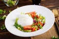 Salad with tomatoes and burrata cheese with lettuce and olive oil on wooden background. Royalty Free Stock Photo