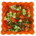 Salad of tomatoes, cucumber, onions, parsley, sweet pepper, herbs. In an orange plate, isolated on a white background Royalty Free Stock Photo