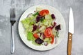 Salad with tomatoes, leaves in a plate on the table.