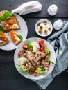 Salad with vegetables, herbs and mozzarella. Fried meat. Panini sandwiches with cheese, tomatoes and arugula. Traditional