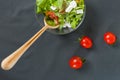 Salad of vegetables with spices. On a wooden surface. Pieces of vegetables, cherry tomatoes, spices, basil