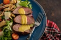 Salad with warm beef with oyster mushrooms, tomatoes and greens.