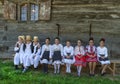 Salaj, Romania-May 13, 2018: Young girls and boys wearing traditional folk costumes in front of a old wooden church in the Royalty Free Stock Photo