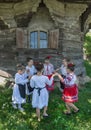 Salaj, Romania-May 13, 2018: Young girls wearing traditional folk costumes dancing in front of a old wooden church in the Royalty Free Stock Photo