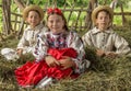 Salaj, Romania - May 15, 2018: young rural girl and boys wearing traditional costumes sitting in a hayloft at harvesting time in