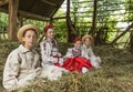 Salaj, Romania - May 15, 2018: young rural girls and boys wearing traditional costumes sitting in a hayloft at harvesting time in