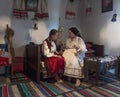 Salaj,Transylvania,Romania-May 14, 2018: mother teaching his young girl in traditional Romanian folk costume how to spin the wool