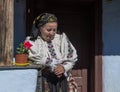 Salaj, Transylvania, Romania-May 14, 2018: old woman dressed in traditional Romanian folk costume sitting on the terrace of her