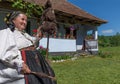 Salaj, Transylvania, Romania-May 14, 2018: old woman dressed in traditional Romanian folk costume, spinning wool in front of her
