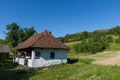 Salaj, Transylvania, Romania-May 14, 2018: rustic traditional little clay house surrounded by tress and hills in the countryside