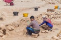 SALALAH, OMAN - FEBRUARY 25, 2017: Workers and archeologists at Sumhuram Archaeological Park with ruins of ancient town Khor Rori