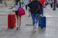 Closeup images of two woman taking a suitcase in city. Royalty Free Stock Photo