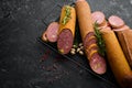Salami with pistachios, hazelnuts and rosemary and spices on a black background. Royalty Free Stock Photo