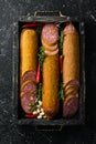 Salami with pistachios, hazelnuts and rosemary and spices on a black background. Royalty Free Stock Photo