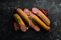 Salami with pistachios, hazelnuts and rosemary and spices on a black background. Royalty Free Stock Photo