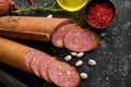 Salami with pistachios, hazelnuts and rosemary and spices on a black background. Royalty Free Stock Photo