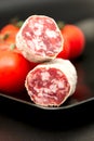 Salami on plate with tomatoes close up