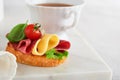 Salami sandwich. Delicious toasted sandwiches with slice salami, cheddar cheese lettuce and tomatoes cherry on white marble Royalty Free Stock Photo