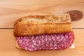 Salami sandwich on rustic wooden table Royalty Free Stock Photo