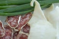 Salami sausage, bacon and green onions on a plate. Cold appetizer