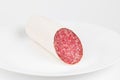 Salami sausage on a white plate, pork snack