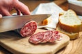 Salami sliced on wooden cutting board. Royalty Free Stock Photo