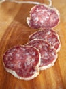 Salami slices on wood trencher Royalty Free Stock Photo