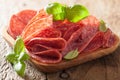 Salami slices in wooden plate