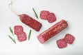 Salami, salami smoked sausage, sliced, on white stone table background, top view flat lay Royalty Free Stock Photo