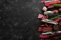 Salami and snacks. Sausage Fouet, sausages, salami, paperoni, on a black stone background. Top view. Royalty Free Stock Photo