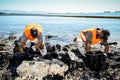 Workers try to clean up oil that has washed ashore, on a beach o