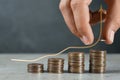 Salary increase concept. Woman stacking coins on grey table and illustration of up arrow Royalty Free Stock Photo