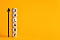 Salary raise or wage increase concept. The word salary on stacked wooden blocks