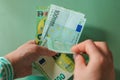 salary of a woman. euro banknotes in hands on a green background. Income of women in European countries.Earnings and