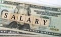 Salary word written on wood block with American Dollar-bills. Directly above. Royalty Free Stock Photo