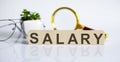 Salary word written on wood block with glasses and magnifier . Business concept Royalty Free Stock Photo