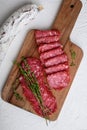 Salchichon whole and sliced cuts, spanish sausage on white surface, flat lay Royalty Free Stock Photo