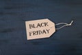 Sale banner with text word Black Friday on cardboard label on dark background Royalty Free Stock Photo