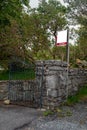 For sale blank sign at a gate of a property on an old stone fence. Real estate business. Mature property on the market to purchase